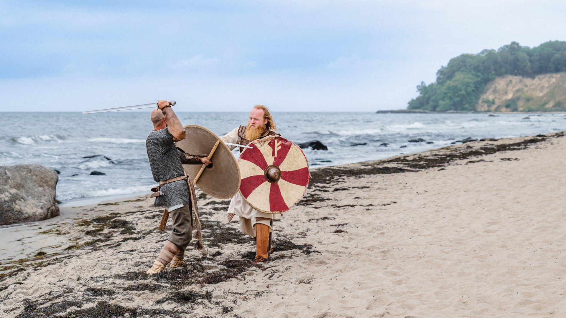 Slav Jaromir (links) en Viking Norde: zij behoren tot de beste vechters in het kamp, © TMV/Tiemann Twee Slaven in Vikingkostuum op het strand in Göhren vechten tegen elkaar tijdens het Vikingfestival.