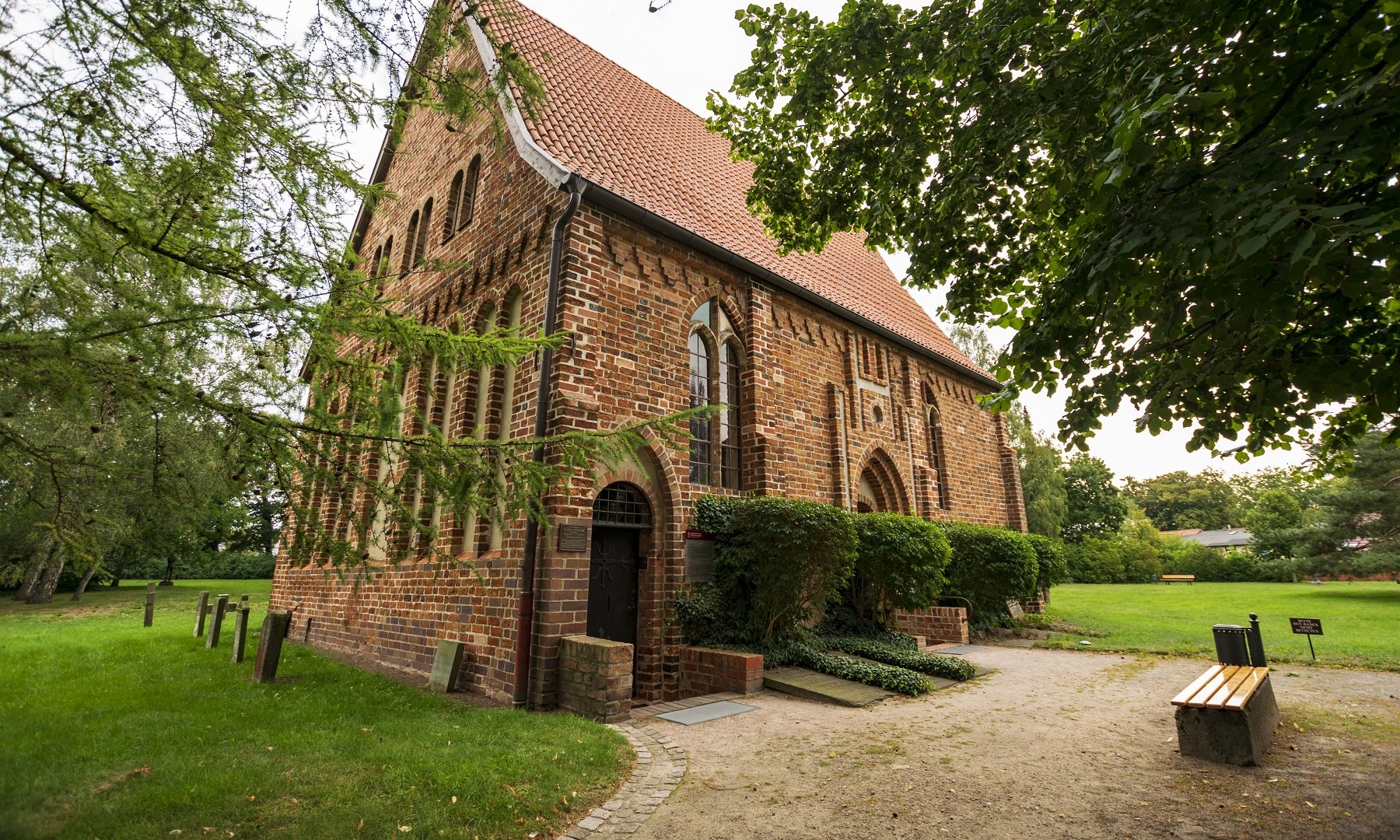 De Getrudenkapelle in Güstrow van de buitenkant., © Steffen Hoffmann De Getrudenkapelle in Güstrow van de buitenkant. De ingang van het bakstenen gebouw met de groene ruimtes eromheen.