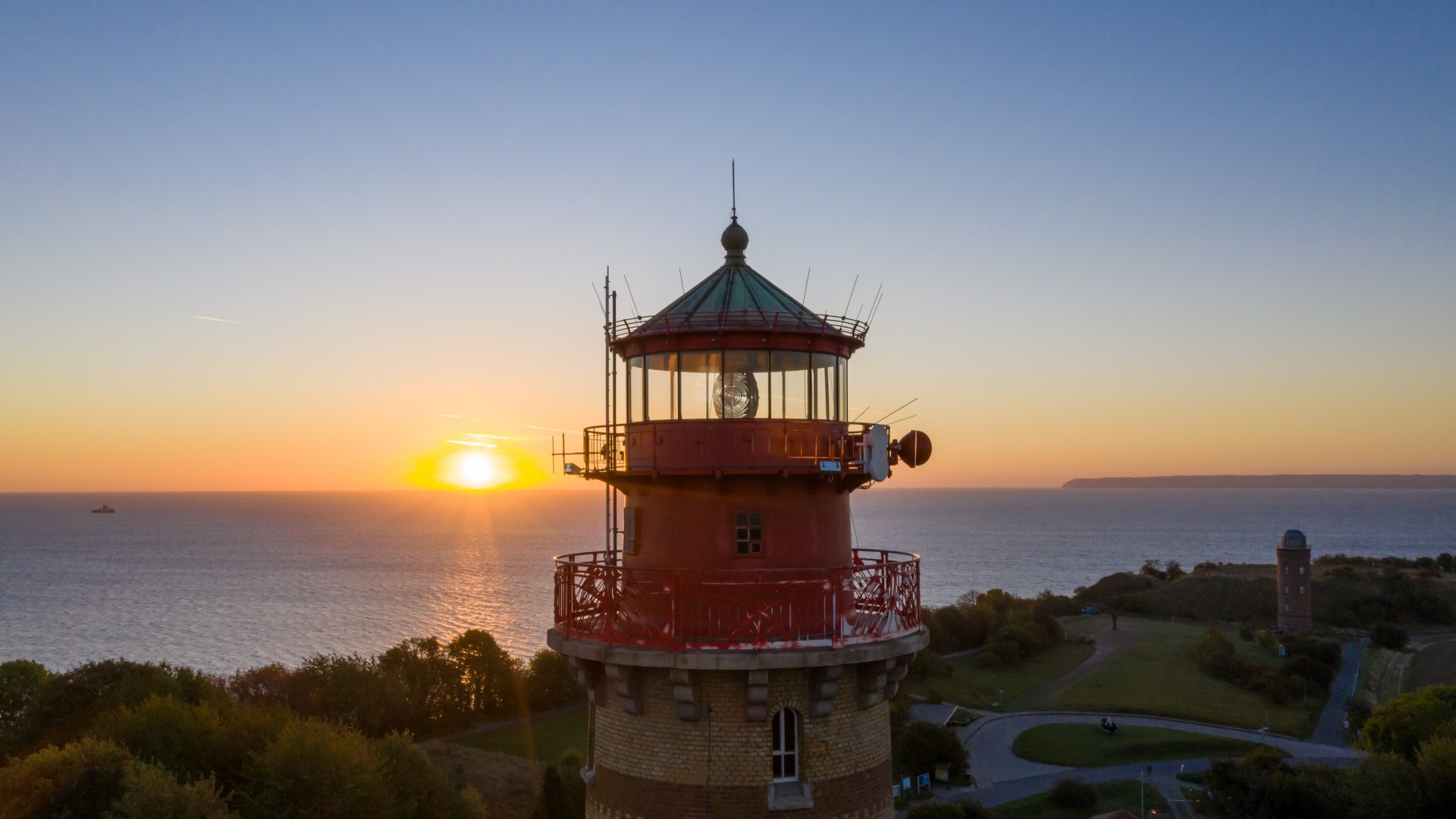 Close-up of the Cape Arkona lighthouse on the island of Rügen at sunset, with a view of the sea and the surrounding area, captured in warm colors.